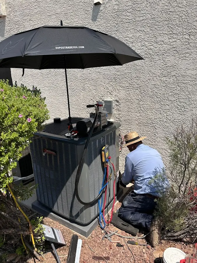 HVAC technician performing outdoor AC maintenance in Selma