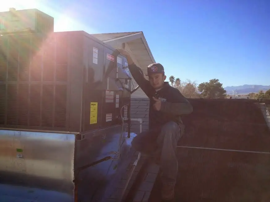 HVAC technician performing AC Tune-Up on a rooftop unit in Selma